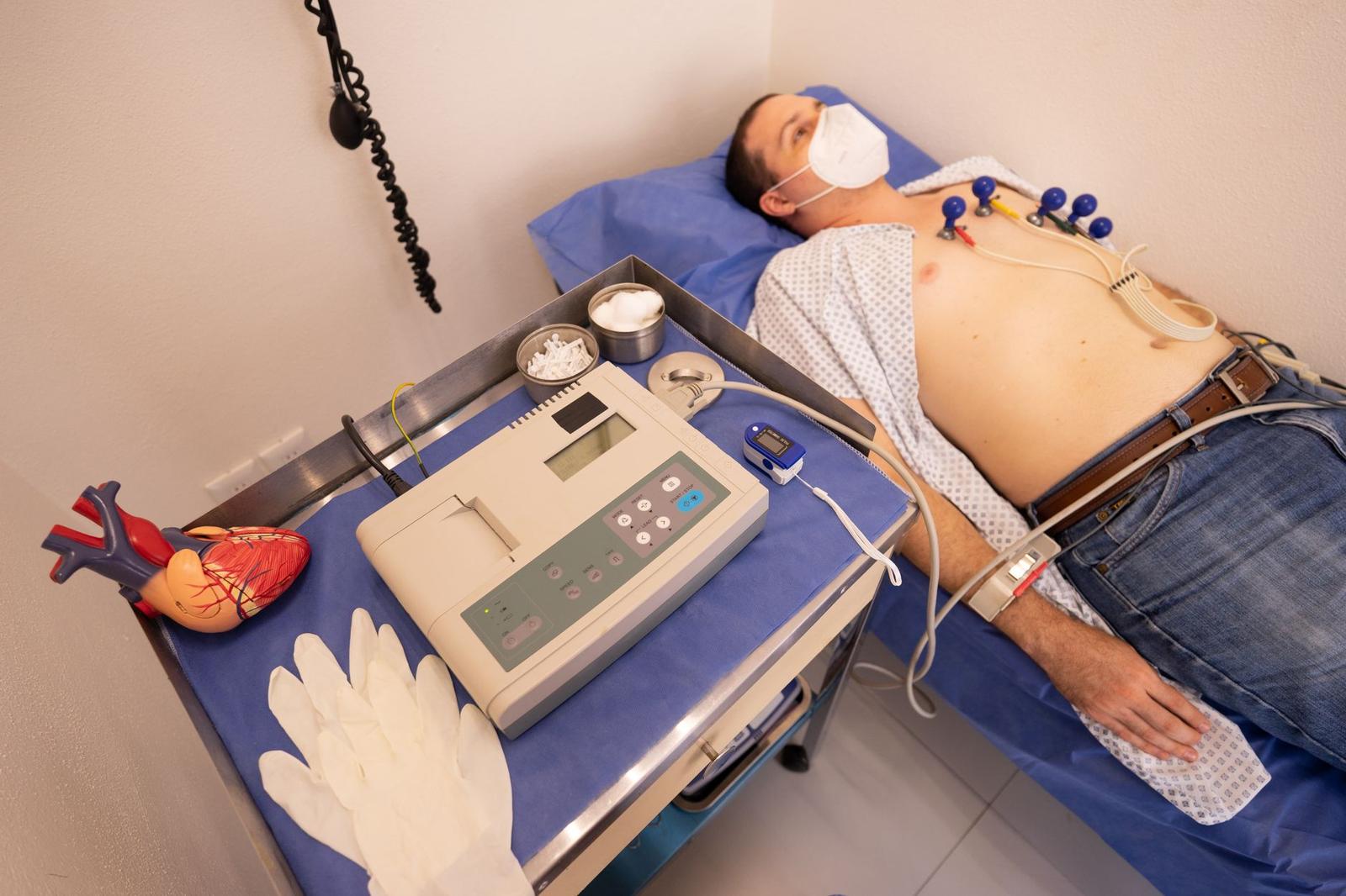 Doctor Performing Auscultation on a Patient Lying on the Bed